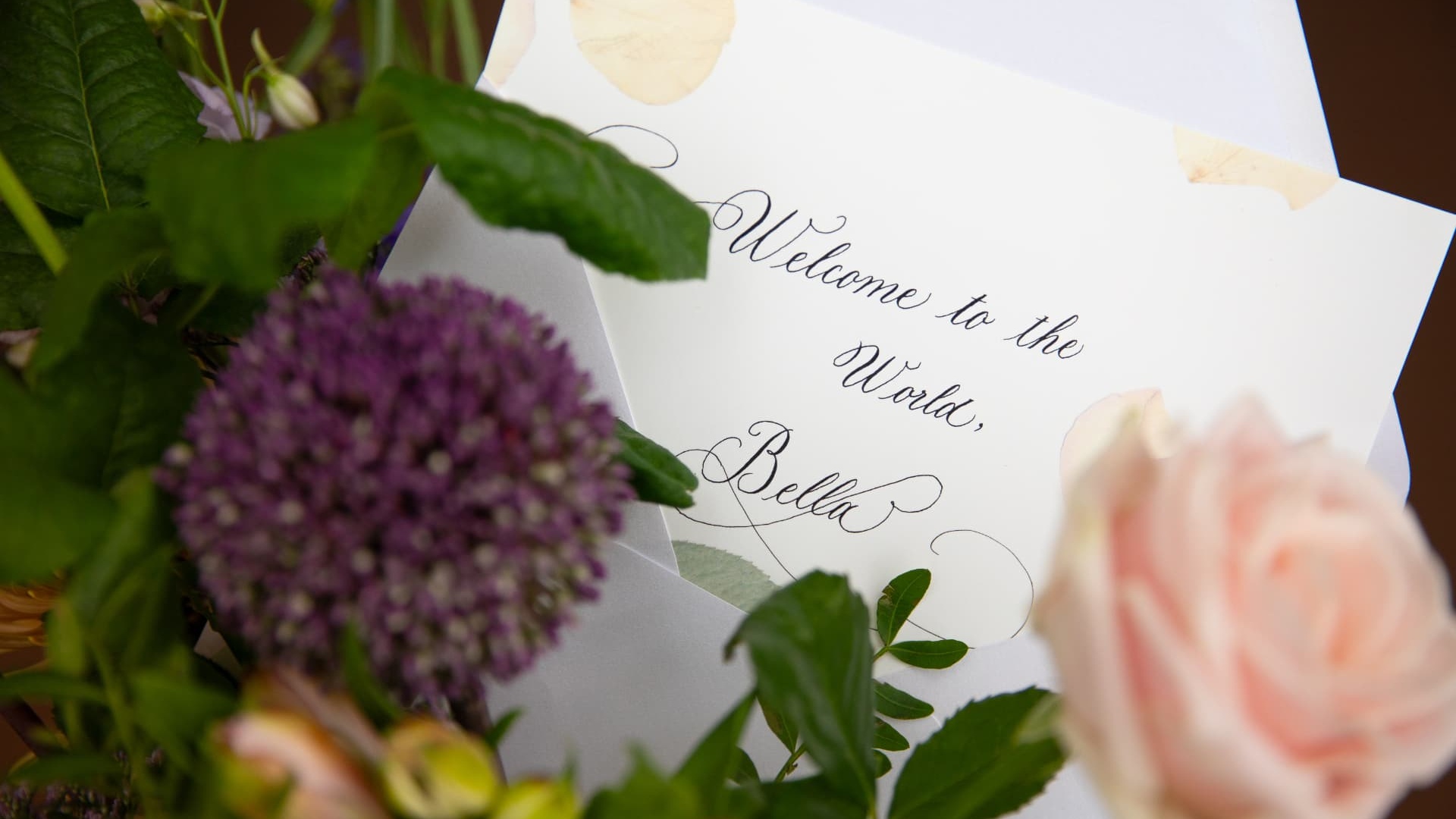 Studio order — hand-lettered welcome card among fresh flowers